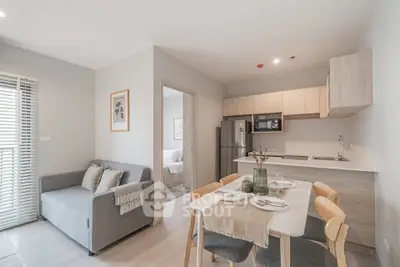 Modern open-plan living room and kitchen with stylish decor and natural light.