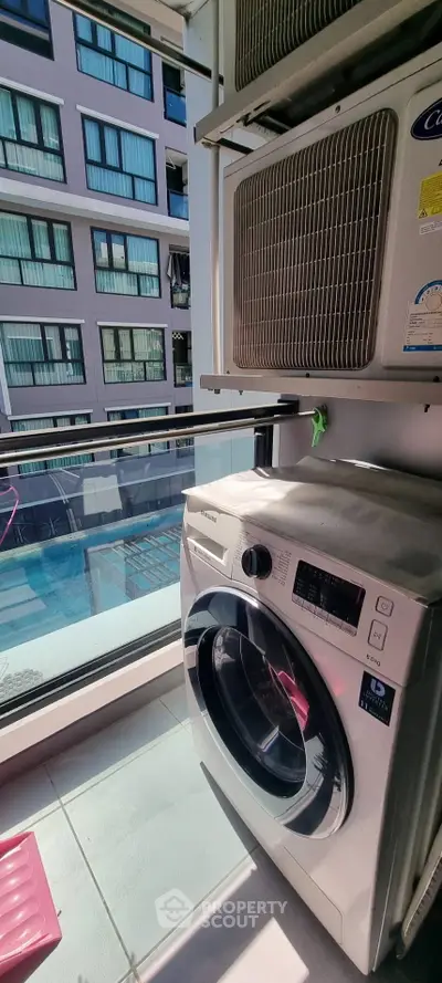 Modern condo balcony with washing machine and pool view, perfect for urban living.