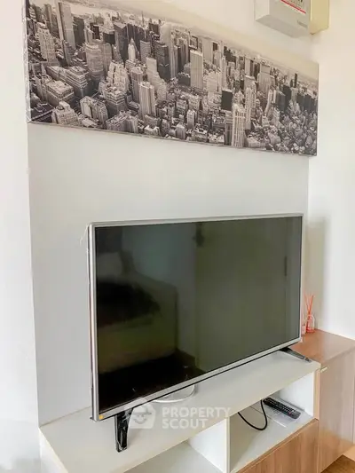 Modern living room with sleek TV and stylish cityscape artwork, perfect for urban living enthusiasts.