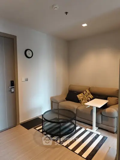 Cozy living room with modern sofa and glass coffee table, perfect for relaxation.
