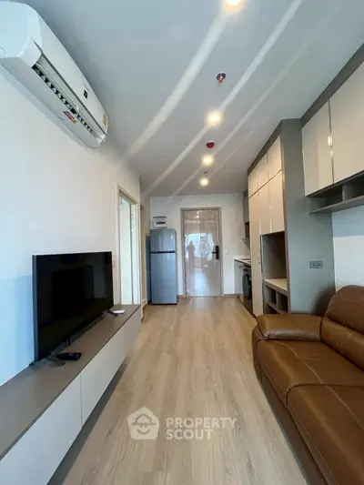 Modern living room with sleek furniture and appliances, featuring a cozy brown leather sofa and wall-mounted TV.