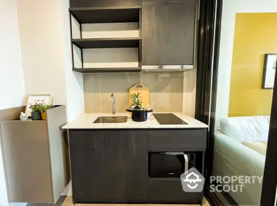 Modern compact kitchen with sleek black cabinetry and built-in appliances