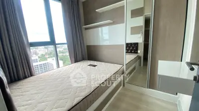 Modern bedroom with large window and mirrored closet in urban apartment