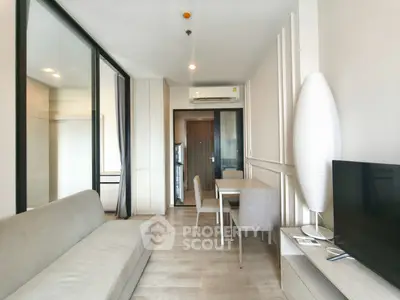 Modern living room with sleek furniture and neutral tones, featuring a cozy dining area and stylish decor.