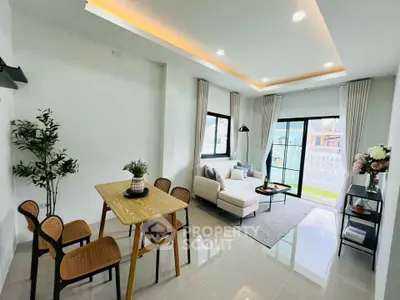 Modern living room with dining area, large windows, and stylish decor in a bright, open space.