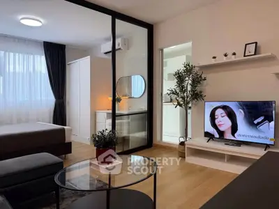 Modern studio apartment with stylish decor, featuring a cozy living area and a sleek kitchen.