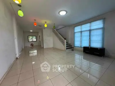 Spacious living room with colorful pendant lights and large windows