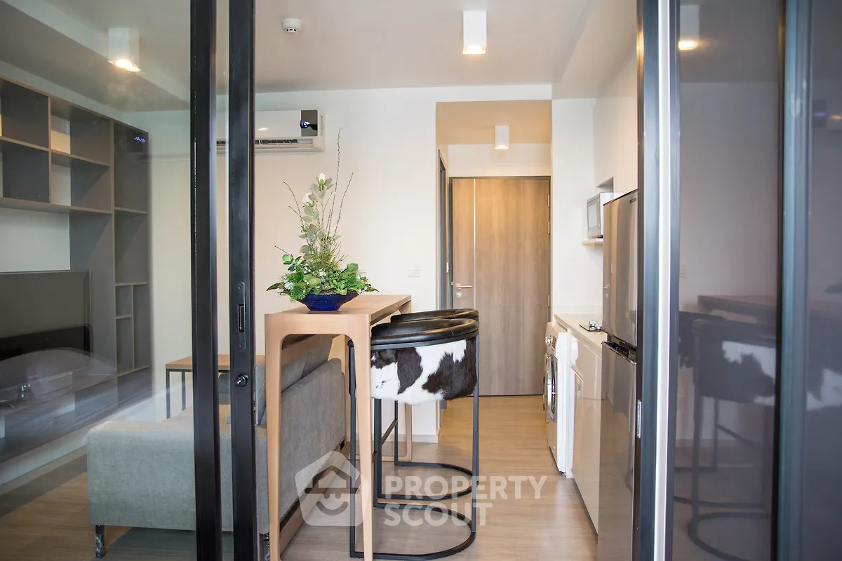 Modern open-plan living room with stylish bar seating and sleek kitchen appliances.
