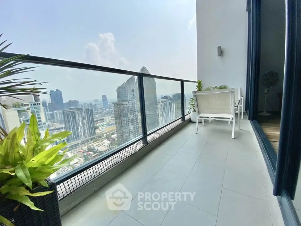 Stunning high-rise balcony with panoramic city views and modern seating area.