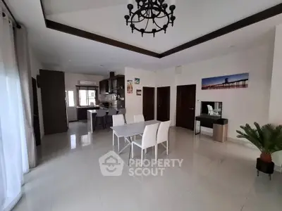 Spacious open-plan living and dining area with modern kitchen and elegant decor.
