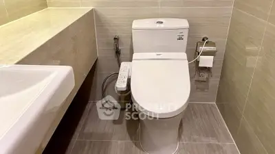 Modern bathroom with sleek toilet and bidet in contemporary design.