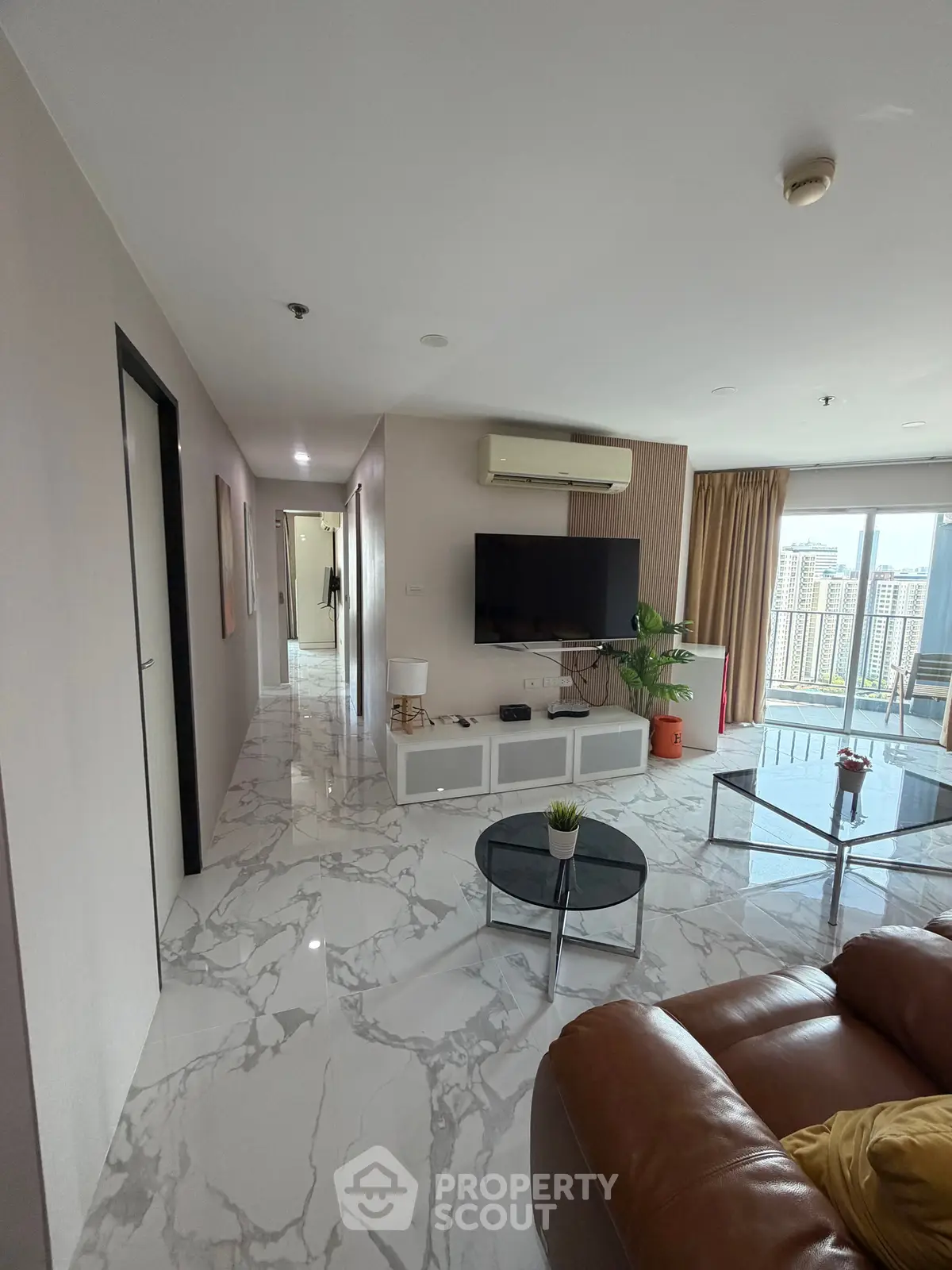 Spacious modern living room with marble flooring and city view balcony