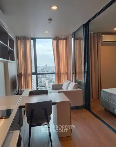 Modern apartment with open layout, featuring a cozy living area and stunning city view.