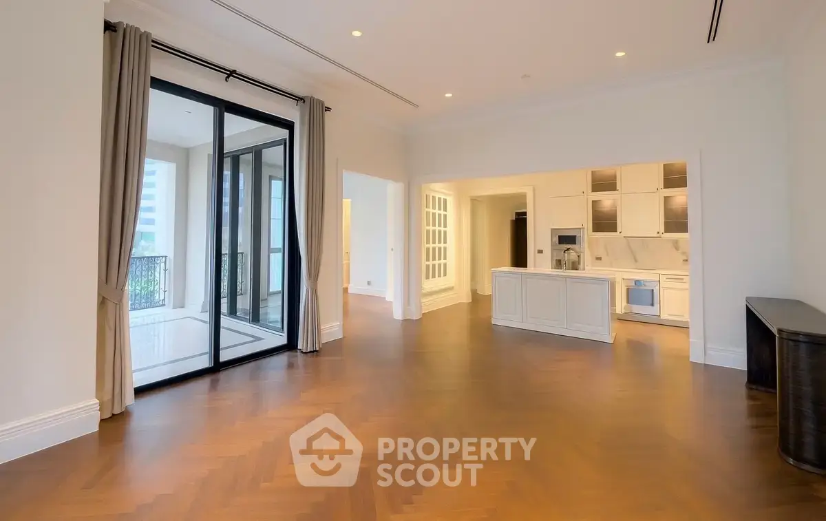 Spacious open-plan living room with elegant kitchen and large balcony access.
