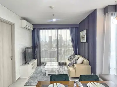 Modern living room with city view, stylish decor, and natural light.