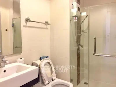 Modern bathroom with glass shower and sleek fixtures in a contemporary home.