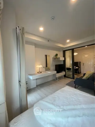 Modern bedroom with sleek design and cozy ambiance, featuring a stylish TV area and elegant furnishings.