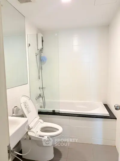 Modern bathroom with sleek design featuring a bathtub and high-tech toilet in a bright, minimalist setting.