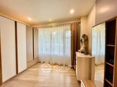 Spacious bedroom with large windows and elegant wooden flooring