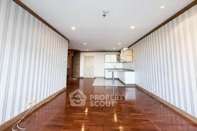 Spacious open-plan living area with wooden flooring and modern kitchen.