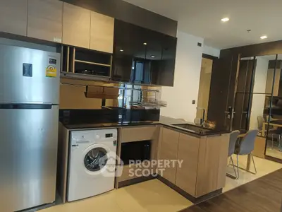 Modern kitchen with sleek appliances and stylish cabinetry in a contemporary apartment.