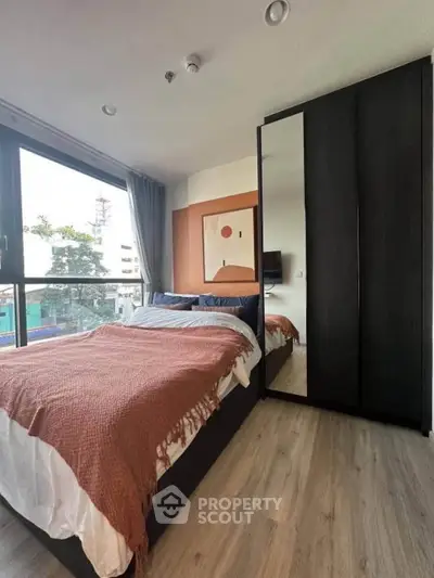 Modern bedroom with large window and stylish decor in urban apartment