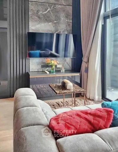 Modern living room with stylish decor, large TV, and cozy seating area, perfect for relaxation and entertainment.