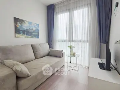 Cozy living room with plush sofa, large window, and modern decor