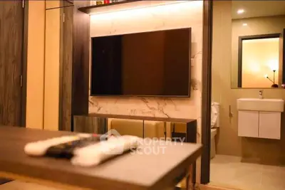 Modern living room with sleek TV setup and adjacent bathroom view