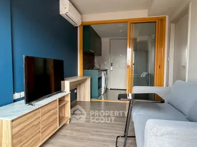 Modern living room with blue accent wall and sliding glass doors to kitchen