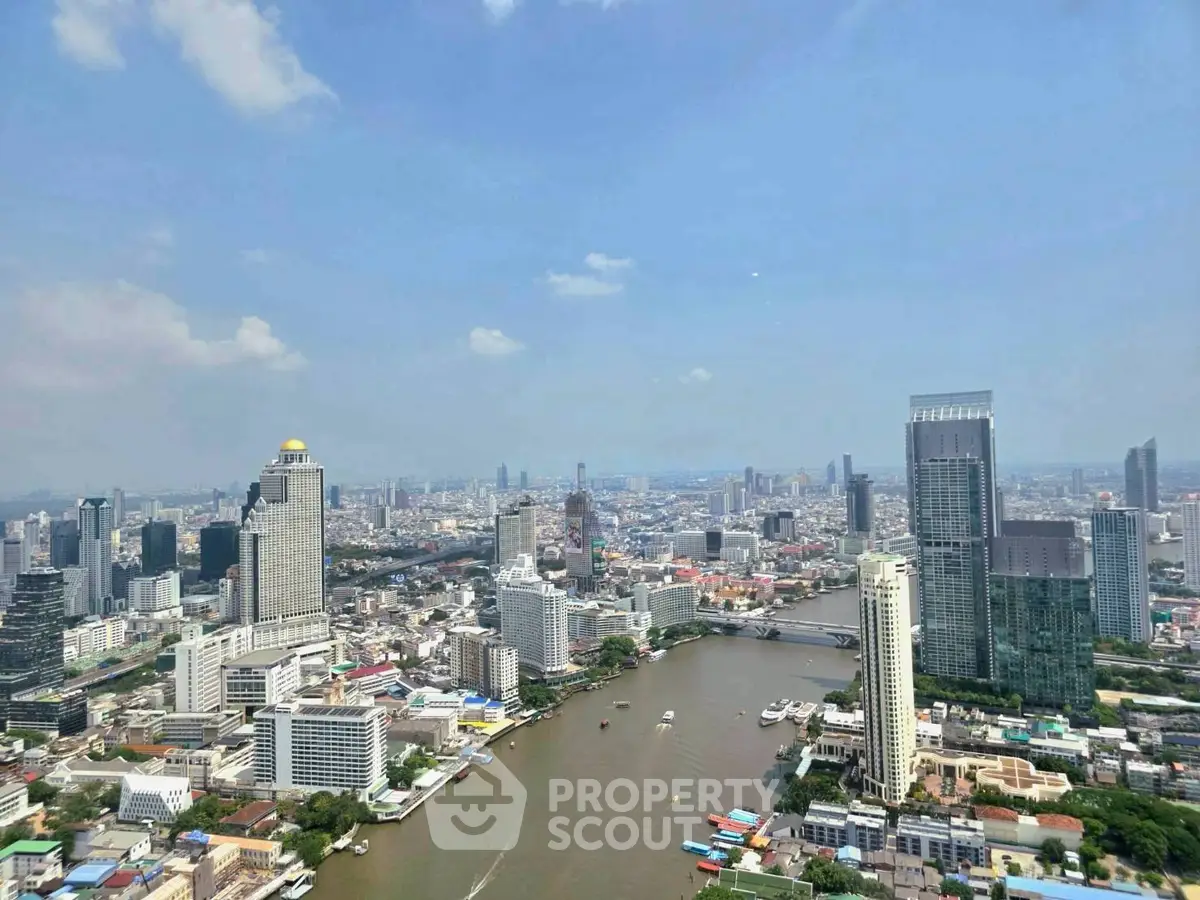Stunning aerial view of a vibrant cityscape with skyscrapers and a winding river under a clear blue sky.