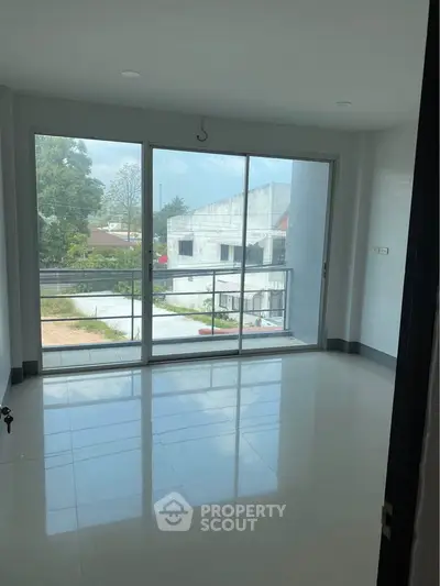 Spacious room with large windows offering a serene view, perfect for modern living.