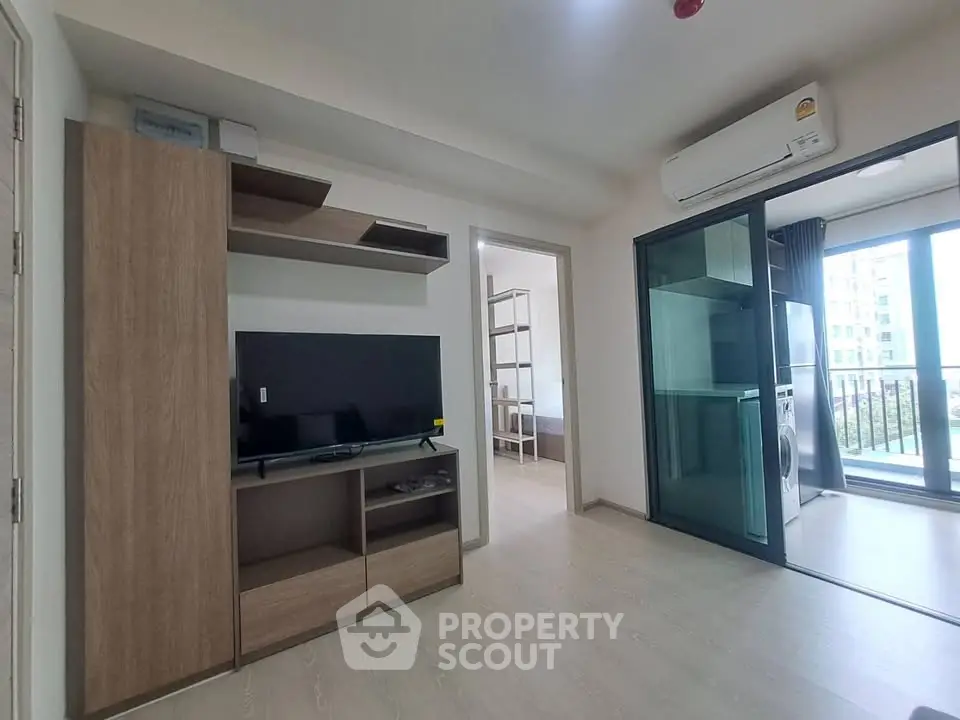 Modern living room with TV, air conditioning, and balcony access in a stylish apartment.