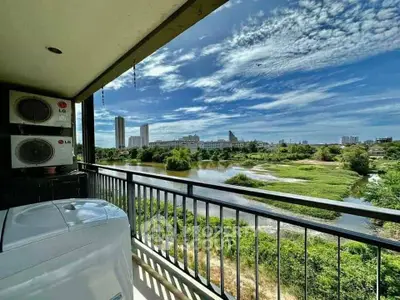 Stunning balcony view overlooking lush greenery and city skyline, perfect for relaxation.