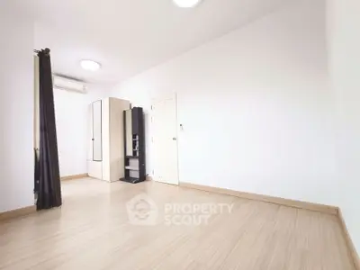 Spacious empty room with wooden flooring and wardrobe, ideal for customization.