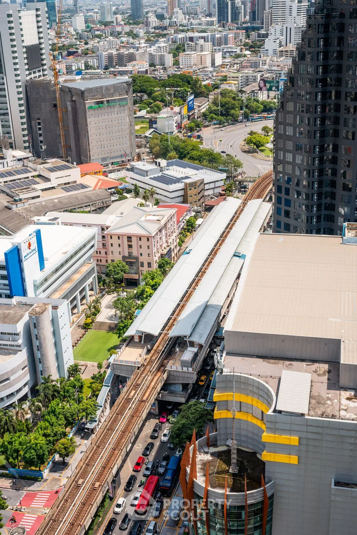 Aerial view of urban cityscape with train tracks and high-rise buildings.