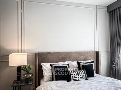 Luxurious bedroom with elegant decor and plush bedding in modern apartment.