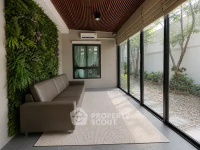 Modern living room with large windows and indoor garden wall