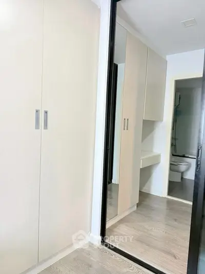 Modern apartment interior with sleek wardrobe and bathroom view