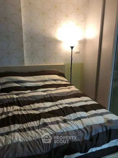 Cozy bedroom with stylish striped bedding and modern lamp lighting