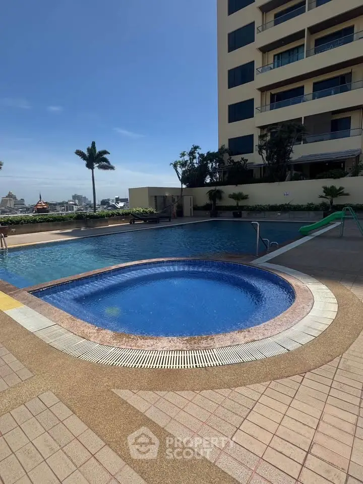 Luxurious apartment complex with stunning pool and city views, perfect for relaxation and leisure.