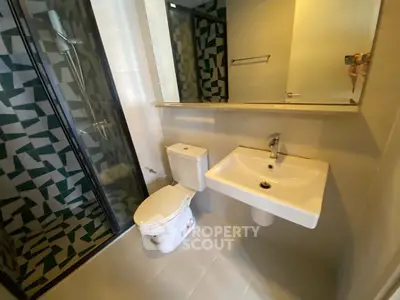 Modern bathroom with sleek fixtures and geometric tile design in a contemporary apartment.