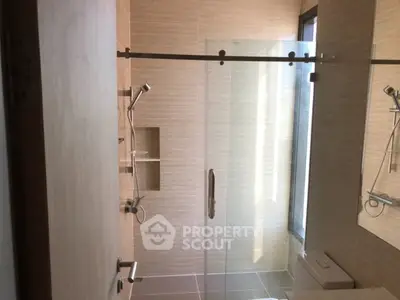 Modern bathroom with glass shower door and sleek fixtures in a contemporary home.