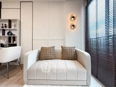 Modern living room with stylish sofa and elegant decor, featuring natural light through large windows.