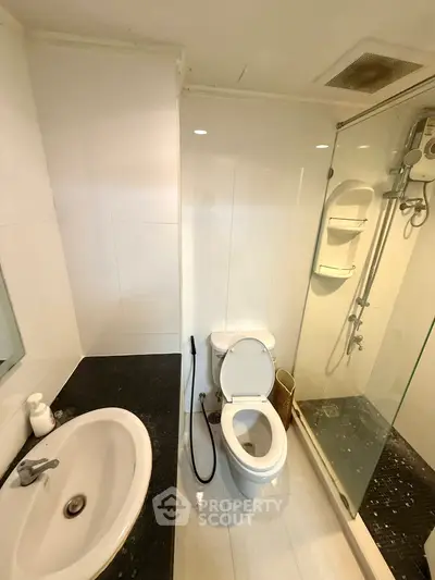 Modern bathroom with sleek design featuring a glass shower and elegant fixtures.