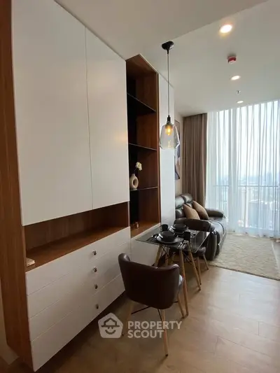Modern living room with stylish furniture and floor-to-ceiling windows offering city views.