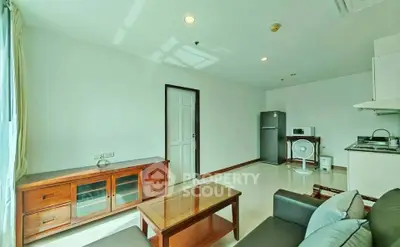 Bright and cozy living room with modern furniture and kitchen area, perfect for urban living.