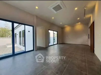 Spacious modern living room with large windows and sleek tile flooring