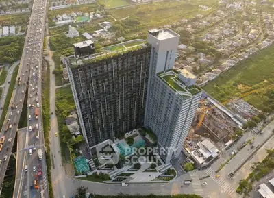 Stunning aerial view of modern high-rise building with pool and lush surroundings, perfect for urban living.