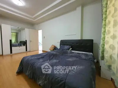 Spacious bedroom with modern decor and wooden flooring